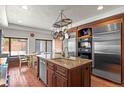 Gourmet kitchen with stainless steel appliances, custom cabinets, granite countertops, and island with sink at 50 Albion St, Denver, CO 80220