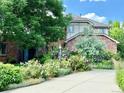 Two-story brick home with mature landscaping, flower beds, and a concrete driveway at 8461 Pawnee Ln, Niwot, CO 80503