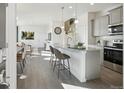 Bright open-concept kitchen featuring modern gray cabinets, granite countertops, and stainless steel appliances at 9865 Biscay St, Commerce City, CO 80022