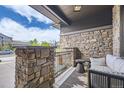 Comfortable front porch with stone columns, outdoor seating, and neutral colors at 1495 W 137Th Ave, Broomfield, CO 80023
