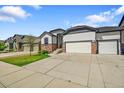 Ranch home with a three-car garage, stone accents, and a well-manicured front lawn and concrete driveway at 6829 Juniper Ct, Frederick, CO 80530