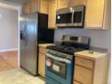 Modern kitchen with stainless steel appliances and light wood cabinets at 2101 S Lowell Blvd, Denver, CO 80219