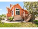 This home features a well-maintained lawn, mature trees, and a charming deck with steps at 19595 Mitchell Dr, Denver, CO 80249