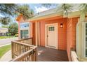 Inviting front porch features wooden railings, light fixture, and paneled door to a cozy orange-sided home at 19595 Mitchell Dr, Denver, CO 80249