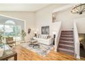 Bright living room features high ceilings, large windows, hardwood floors, and an open staircase at 19595 Mitchell Dr, Denver, CO 80249