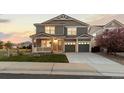 Charming two-story home with a covered porch, attached garage, and beautiful landscaping at 1983 Candleglow St, Castle Rock, CO 80109