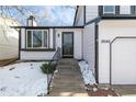 Front entrance of a two-story house with white siding and black accents at 8946 W Teton Cir, Littleton, CO 80128