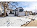 Two-story house with white siding, a two-car garage, and a snow-covered front yard at 8946 W Teton Cir, Littleton, CO 80128