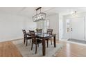 Cozy dining area features a modern light fixture, hardwood floors, and seating for six at 10885 Longs Peak Ln, Parker, CO 80138