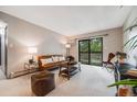 Inviting living room with comfortable seating, a modern entertainment center, and balcony access at 7770 W 38Th Ave # 207, Wheat Ridge, CO 80033