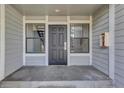 Welcoming entryway with a sturdy black door framed by windows and siding detail at 14467 E 1St Dr # A04, Aurora, CO 80011