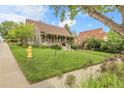 Charming home featuring a well-maintained lawn, lush greenery, and a quaint front porch at 503 15Th St, Golden, CO 80401