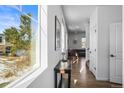 Bright hallway with wood floors, leading to the living room and stairs at 5445 Canyon View Dr, Castle Rock, CO 80104