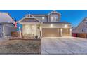 Inviting home with a covered porch, American flag, three-car garage, and landscaped front yard at 12988 E 108Th Pl, Commerce City, CO 80022