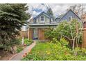 Charming front yard with mature trees, green grass, and colorful garden at 2514 N Humboldt St, Denver, CO 80205