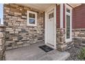 Close up of front door showcasing stone accents and siding, including an Oakwood Life welcome mat at 4955 N Picadilly Ct, Aurora, CO 80019