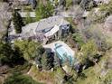 Breathtaking aerial view of a luxurious home with a sparkling pool and beautifully landscaped grounds at 5550 Preserve Dr, Greenwood Village, CO 80121