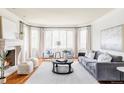 Bright and airy living room featuring hardwood floors, a fireplace, and large windows with elegant drapery at 5550 Preserve Dr, Greenwood Village, CO 80121