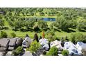Aerial view of a home near a beautiful pond and lush green golf course at 14186 E Hampden Pl, Aurora, CO 80014