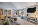 Bright living room with large windows, plush sofa, and modern entertainment setup at 3647 S Uravan St, Aurora, CO 80013