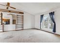 Bright living room with a large window, bookshelves, and neutral carpet at 10241 Routt St, Broomfield, CO 80021