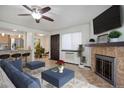 Comfortable living room with a fireplace, ceiling fan, and an open view into kitchen and dining area at 14590 E 2Nd Ave # B309, Aurora, CO 80011