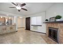 Bright living room featuring a fireplace, a ceiling fan, and a view into the kitchen and entry way at 14590 E 2Nd Ave # B309, Aurora, CO 80011