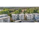 Aerial view showcases the condo buildings, lush trees, parking areas and the surrounding neighborhood at 1308 Snowberry Ln # 303, Louisville, CO 80027