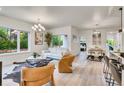 Bright, open-concept living and dining area with modern decor, hardwood floors, and large windows overlooking lush greenery at 1308 Snowberry Ln # 303, Louisville, CO 80027