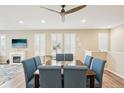 Inviting dining room featuring a wooden table with blue upholstered chairs and plantation shutters at 9162 Star Streak Cir, Littleton, CO 80125