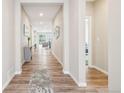 Bright hallway with wood floors that leads to an open living space. Recessed lights and neutral paint at 9162 Star Streak Cir, Littleton, CO 80125