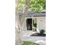 A modern black front door is framed by a light stucco exterior and a meticulously manicured garden at 3901 S Dexter St, Cherry Hills Village, CO 80113