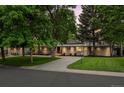 Attractive home with a well-kept front lawn, mature trees, and a long driveway at 3901 S Dexter St, Cherry Hills Village, CO 80113
