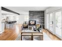 Bright living room with a modern fireplace and exposed beam, leading to an open-plan kitchen at 3901 S Dexter St, Cherry Hills Village, CO 80113