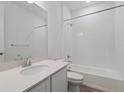 Spotless white bathroom featuring shower over tub, sink, toilet and chrome fixtures at 8317 Snake River St, Littleton, CO 80125