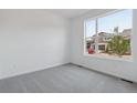 Bright bedroom featuring neutral carpet, white walls and a large window at 8317 Snake River St, Littleton, CO 80125