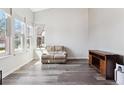 Bright living room features hardwood floors, ample natural light from large windows, and contemporary décor at 13199 Ash St, Thornton, CO 80241