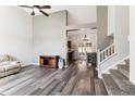 Spacious living room with high ceilings, hardwood floors, neutral paint, and open access to kitchen and staircase at 13199 Ash St, Thornton, CO 80241