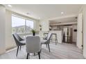 Dining area with a marble-top table, stylish chairs, and an open view into the kitchen at 3275 S Decatur St, Denver, CO 80236