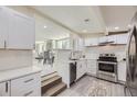 Modern kitchen with white cabinetry, stainless steel appliances, and an open design for easy entertaining at 3275 S Decatur St, Denver, CO 80236