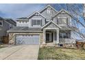 Inviting two-story house featuring a covered front porch and attached two-car garage at 11591 S Maiden Hair Way, Parker, CO 80134