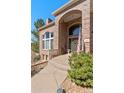 Inviting front entrance featuring a brick archway, a decorative wreath, and an American flag at 19281 E Hinsdale Ln, Centennial, CO 80016