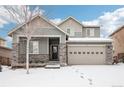 Two-story house with gray siding, stone accents, and a three-car garage at 7916 S Grand Baker Way, Aurora, CO 80016