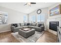 Spacious living room with L-shaped sofa, fireplace, and large windows at 7916 S Grand Baker Way, Aurora, CO 80016