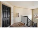 Welcoming condo entryway with a black front door and staircase at 5714 N Gibralter Way # 5-306, Aurora, CO 80019