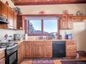 Well-lit kitchen with wood cabinets, marble countertops, and stainless steel appliances at 13012 S Wamblee Valley Rd, Conifer, CO 80433