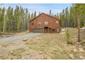 Charming wood home nestled among towering pine trees with a well-maintained gravel driveway at 79 Beaver Rd, Idaho Springs, CO 80452