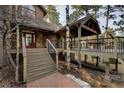 Inviting home exterior featuring stairs leading to a deck, complemented by stone accents at 31332 Island Dr, Evergreen, CO 80439