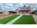 Charming brick home featuring an artifical lawn and a welcoming covered porch, enhancing curb appeal at 3242 N Albion St, Denver, CO 80207