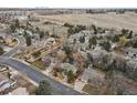 Aerial view of home with fenced-in yard nestled in a residential neighborhood surrounded by mature trees at 2492 S Yarrow St, Lakewood, CO 80227